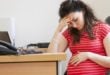 tired pregnant woman in office
