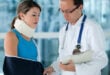 Doctor examining an injured woman with a bandage on her neck and arm